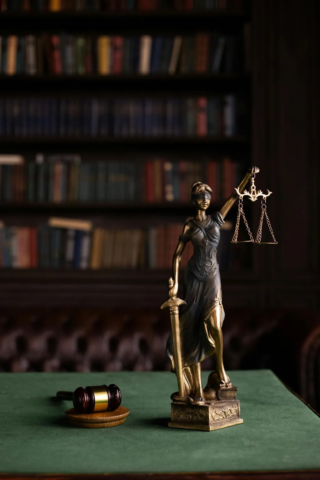 Lady Justice statue beside a gavel, symbolizing criminal defense
