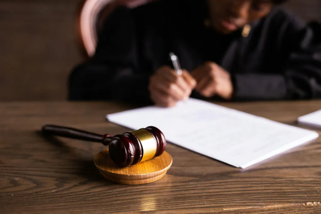 Judge's gavel next to a person signing legal papers